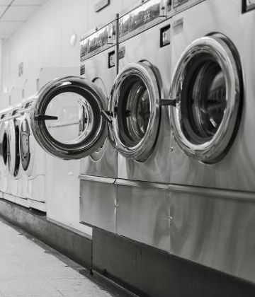 Open doors on a row of front-loading washing machines
